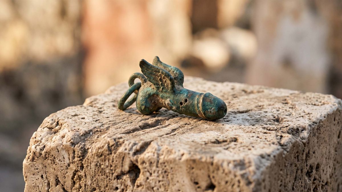 Weathered Roman bronze protective charm on stone, symbol against the evil eye in ancient Rome