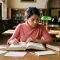 Una mujer estudiando un léxico anatómico latino abierto en una sala de lectura de una biblioteca, ilustrando el origen y el uso correcto del término vulva